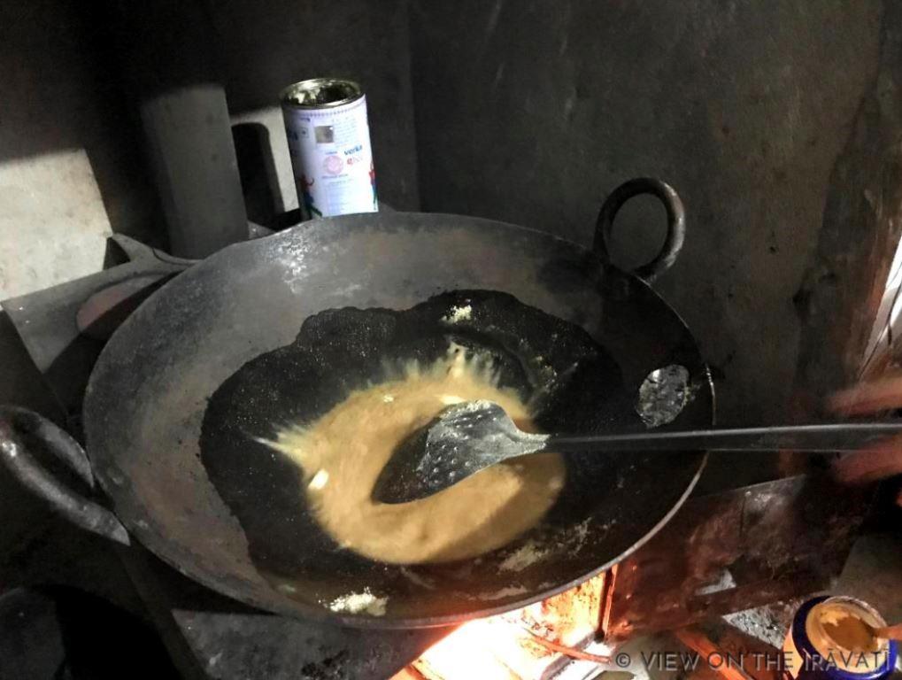 mixing ingredients for alsi laddus on a wood burning stove