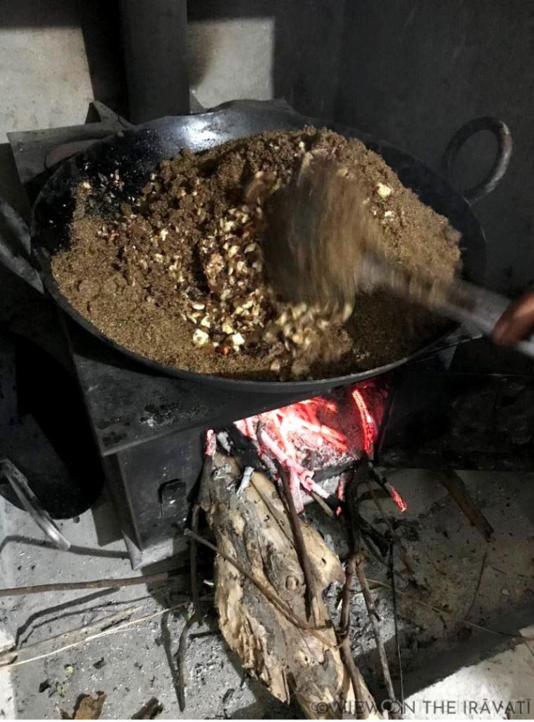 mixing ingredients for alsi laddus on a wood burning stove