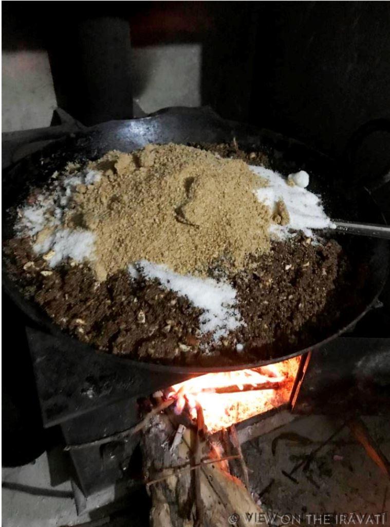 mixing ingredients for alsi laddus on a wood burning stove