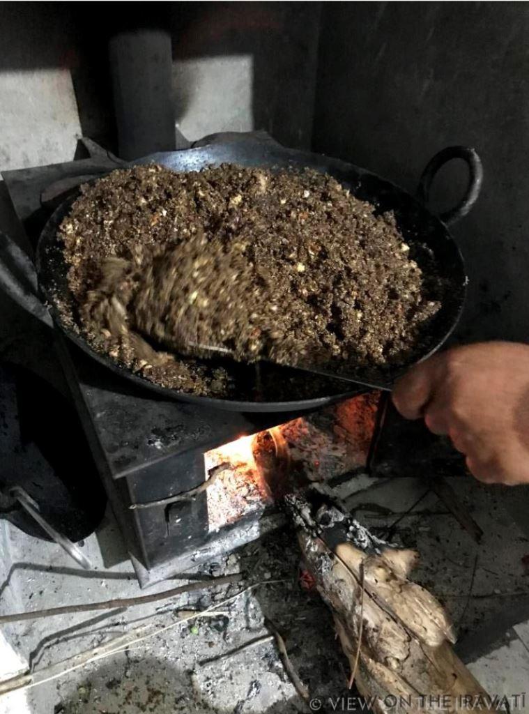 mixing ingredients for alsi laddus on a wood burning stove