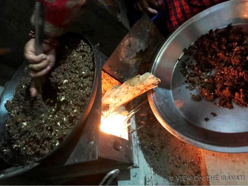 Taking heated flax mixture for sweet off of the flame